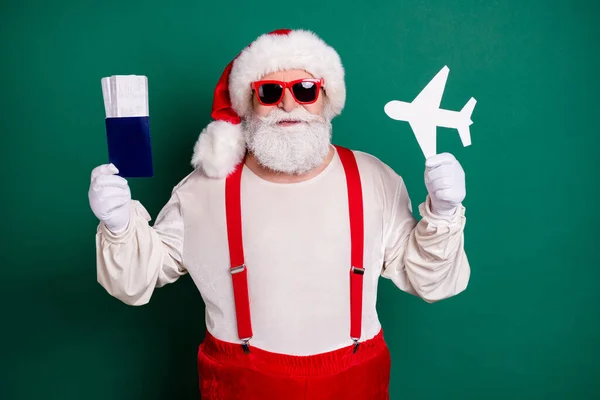 Portrait of his he handsome bearded cheerful funky fat overweight Santa father holding in hand paper plane shape ticket document tour resort destination first class isolated green color background — Stock Photo, Image