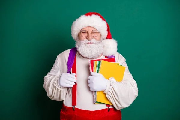 Portrait seiner schönen schönen übergewichtigen bärtigen fröhlichen Weihnachtsmann hält in den Händen Kopiermaterial aus der Schule Herbstsaison isoliert über grünem Hintergrund — Stockfoto