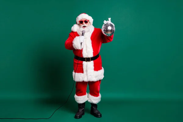 Full length body size view of his he nice handsome bearded cheerful Santa grandfather soloist star singing single pop hit having fun celebratory holding silver ball isolated green color background — Stock Photo, Image