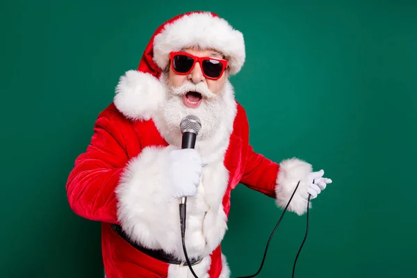 Portrait of his he nice attractive handsome bearded cheerful cheery funky funny childish cool Santa singing rock pop genre hit single having fun isolated over green color background — Stock Photo, Image