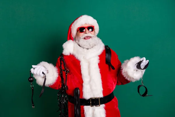 Portret van zijn hij mooie aantrekkelijke vrolijke vrolijke baard grappig Santa vader houden in handen apparatuur gereedschap kinky pervert spel met plezier geïsoleerd over groene kleur achtergrond — Stockfoto