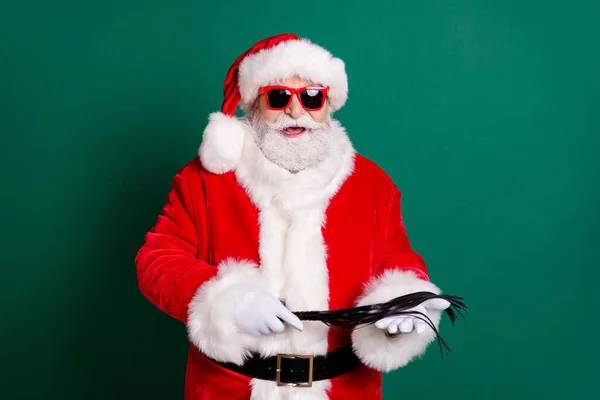 Sei cattivo quest'anno. Funky pazzo Babbo Natale tenere frusta in pelle newyear x-mas magico miracolo donna regalo indossare rosso cappello costume isolato su sfondo di colore verde scuro — Foto Stock