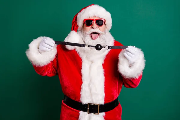 Zdjęcie niegrzeczny szalony Mikołaj pokazać język-out dostarczyć x-mas Boże Narodzenie noc północ obecna kobieta trzymać skórzany knebel nosić czerwony kostium głowy izolowane na zielonym tle kolor — Zdjęcie stockowe