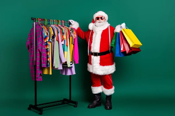 Pleine longueur vue de la taille de son il il belle graisse gai Père Noël acheteur visite centre de sortie marchandage portant achats choses choisir saison vêtement isolé sur fond de couleur verte — Photo