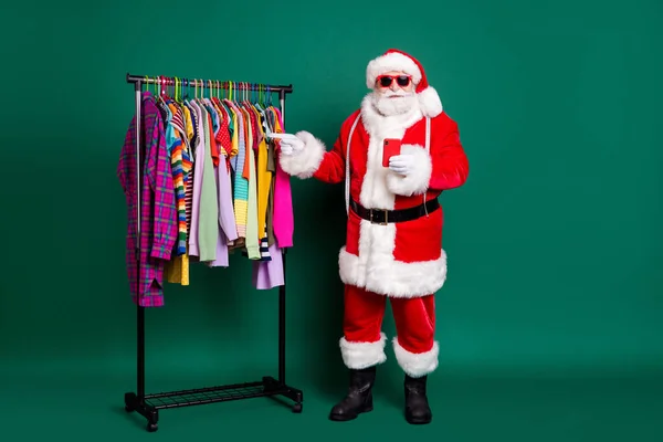 Full length photo of santa claus noel tradition x-mas designer point index finger clothing clothing shopper buyer buy wear red κοστούμι headwear isolated over green color background — Φωτογραφία Αρχείου