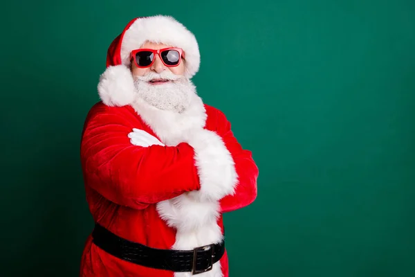 Nowy Zbawiciel Roku. Zdjęcie emeryta dziadek szary broda skrzyżowane ręce pewność pustej przestrzeni uśmiechając się nosić czerwony Santa strój płaszcz rękawiczki pas okulary przeciwsłoneczne głowy odizolowany zielony kolor tło — Zdjęcie stockowe