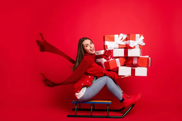 Pleine longueur profil taille du corps vue de côté d'elle elle attrayant heureux gai fille équitation traîneau avoir du plaisir à livrer des boîtes-cadeaux Eve Noel isolé brillant vif vibrant fond de couleur rouge — Photo