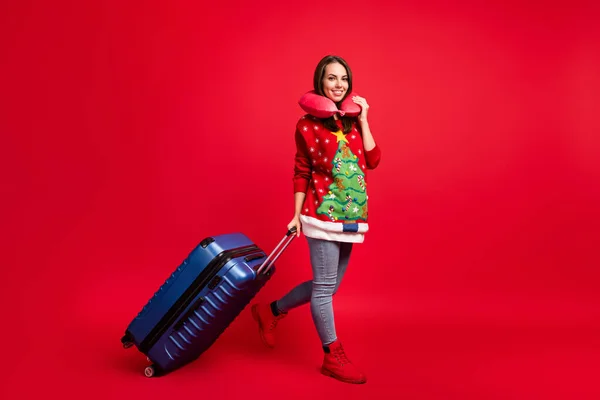 全身上下都是她迷人的容貌，笑容满面的女孩背着行李走着离开目的地航班国际旅游与世隔绝鲜亮鲜亮的红色底色 — 图库照片