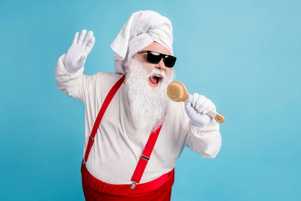 Photo of pensioner old fat man grey beard hold body brush sing shower pretend hold mic play funny game wear santa x-mas costume towel turban suspender sunglass isolated blue color background — Stock Photo, Image