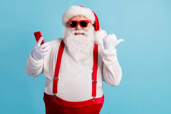 Porträtt av hans han trevlig attraktiv glad glad glad glad säker vithårig Santa med hjälp av enheten visar kopiera utrymme 5g app isolerad ljus levande glans levande blå färg bakgrund — Stockfoto