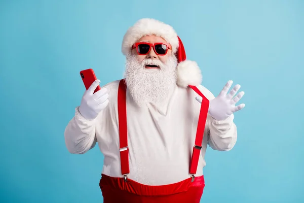 Portrait de son il agréable gai joyeux joyeux Père Noël aux cheveux blancs en utilisant l'appareil 5g app réseau social blogging boutique commander vente avoir du plaisir isolé lumineux vif éclat vibrant fond de couleur bleue — Photo