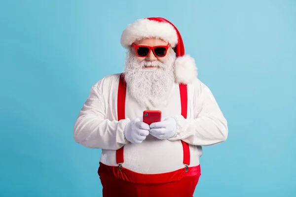 Portret van zijn hij mooie aantrekkelijke vrolijk gerichte witharige Kerstman met behulp van apparaat gadget 5g app chatten bloggen winkel orde geïsoleerde heldere levendige glans levendige blauwe kleur achtergrond — Stockfoto