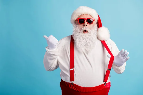 Porträtt av hans han trevlig attraktiv förvånad bedövad vithårig Santa visar kopia utrymme annons annons lösning beslut dra hängslen isolerad ljus levande glans levande blå färg bakgrund — Stockfoto