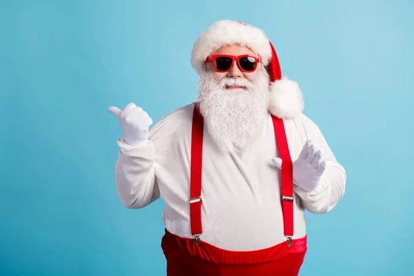 Portrait of his he nice attractive cheerful cheery white-haired Santa demonstrating copy space advice advert ad look idea pulling suspender isolated bright vivid shine vibrant blue color background