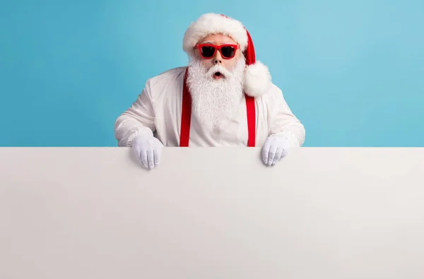 Retrato de su agradable atractivo funky sorprendido aturdido de pelo blanco Santa celebración en las manos copia espacio tablero anuncio atención aislado sobre brillante brillo vivo vibrante color azul fondo — Foto de Stock