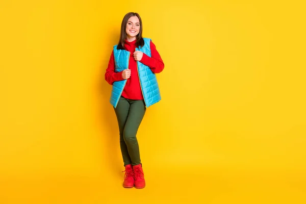 Pleine taille photo de charmante jeune femme rayonnant souriant enveloppant vêtements chauds froid porter pantalon vert gilet bleu bottes pull rouge isolé fond de couleur jaune vif — Photo