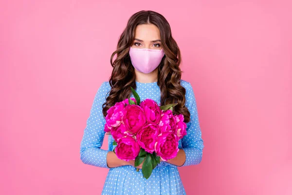 Portrait of her she attractive pretty feminine wavy-haired lady wearing reusable mask holding in hand floral fresh bouquet stop influenza mers cov flu flue grippe isolated pink pastel color background — Stock Photo, Image