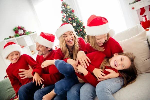 Full familj kul jul kväll noel. Människor mamma pappa små barn kittla syster på soffan i huset inomhus med julgran dekoration tinsels — Stockfoto