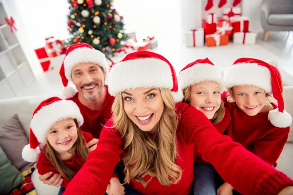 Celá rodina x-mas čas předvečer adventní událost. Lidé maminka tatínek tři preteen malé děti, aby selfie pozdrav 2021 novoroční nosit Santa Claus klobouky v domě s vánoční stromeček ozdoba — Stock fotografie