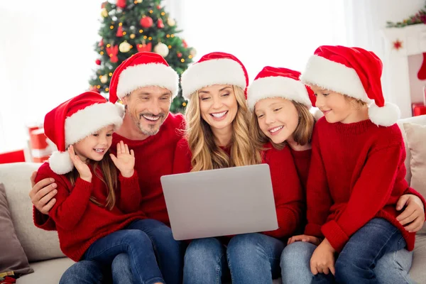 Повна родинна Різдвяна відпустка. Люди мама тато тато сидить диван відео чат родичі ноутбук вітання з різдвяним носінням Санта-Клаус капелюхи в будинку в приміщенні з традиційним орнаментом — стокове фото