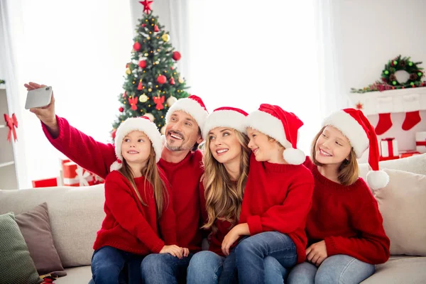 Volle familie kerstvakantie. Mensen mamma pappa pappa drie tieners zitten sofa selfie mobiele telefoon in huis binnen met kerst boom avond noel decoratie dragen kerstman hoeden — Stockfoto