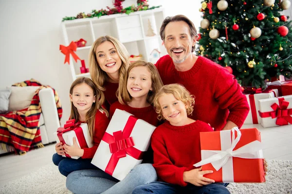 Foto der großen Familie fünf Menschen versammeln drei kleine Kinder halten Weihnachtsgeschenke glückliche Kindheit tragen rote Pullover Jeans im heimischen Wohnzimmer Baumgirlande viele Geschenk-Boxen drinnen — Stockfoto