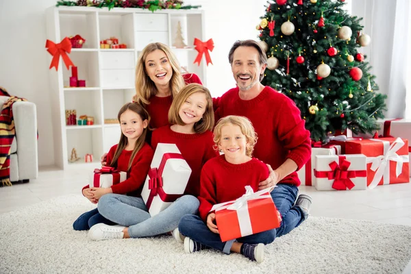 Foto van een grote familie vijf mensen ontmoeten drie kleine kinderen houden geschenken stralende glimlach avond dragen rode trui in huis woonkamer x-mas boom lichten veel aanwezig dozen binnen — Stockfoto