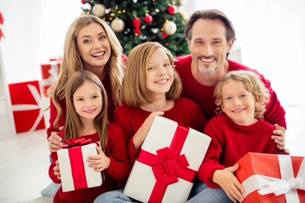 Foto van volledige grote familie vijf mensen verzamelen drie kleine kinderen houden huidige dozen tandenglimlach hechting sfeer dragen rode jumper in huis woonkamer veel x-mas geschenken binnen — Stockfoto