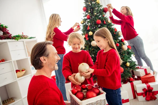 Foto de família grande cheia cinco pessoas encontrando três crianças pequenas decorar x-mas árvore filha demonstrar bola de ouro pai usar jeans jumper vermelho em casa sala de estar visco dentro de casa — Fotografia de Stock