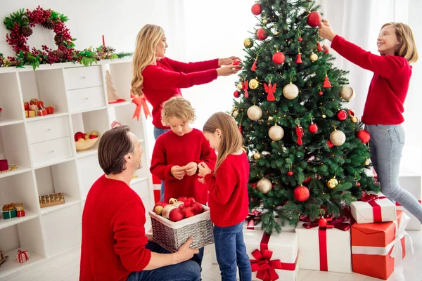 Foto van volledige grote familie vijf mensen ontmoeten drie kleine kinderen versieren x-mas boom vader hold bag speelgoed helpen zoon dragen rode trui jeans in huis woonkamer veel gift box maretak binnen — Stockfoto