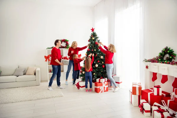 Foto van volledige grote familie vijf mensen ontmoeten drie kleine kinderen versieren x-mas boom vader helpen mand kerstballen slinger dragen rode trui jeans in huis woonkamer veel geschenkdoos binnen — Stockfoto
