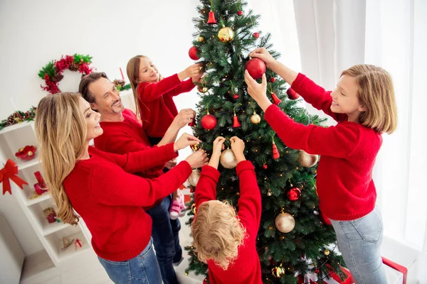 Foto van volledige grote familie vijf mensen verzamelen geliefden ouders drie kleine kinderen versieren x-mas boom hold ballen vader helpen dochter lichten dragen rode trui jeans in huis woonkamer binnen — Stockfoto