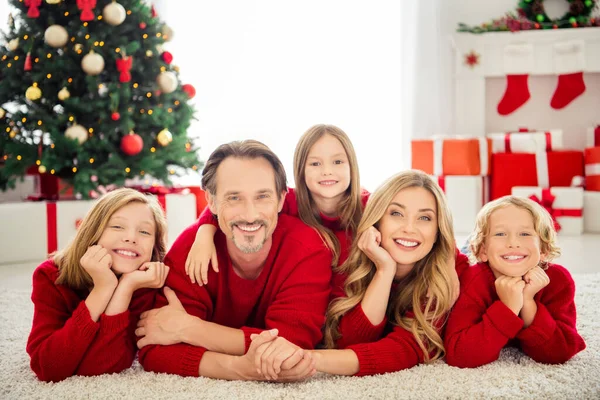 Foto van hele grote familie vijf mensen ontmoeten drie kleine kinderen knuffelen hand wangen liggen vloerkleed tandenglimlach dragen rode trui in woonkamer x-mas boom lichten giftboxen binnen — Stockfoto