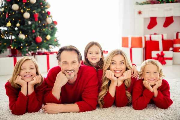 Zdjęcie pełnej dużej rodziny pięć osób spotyka trójkę małych dzieci przytula zębaty uśmiech dłonie policzki leżą podłogi dywan nosić czerwony sweter w salonie x-mas drzewa światła pudełka prezentów wewnątrz — Zdjęcie stockowe