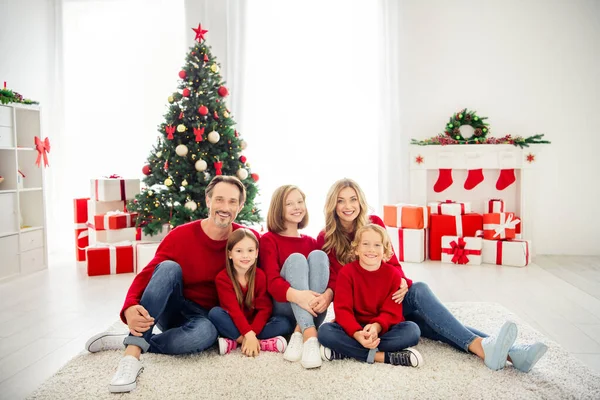 Full length foto van grote familie vijf mensen verzamelen drie kleine kinderen knuffelen zitten tapijt dragen rode trui jeans in woonkamer x-mas voorbereiding evergreen boom cadeau dozen binnen — Stockfoto