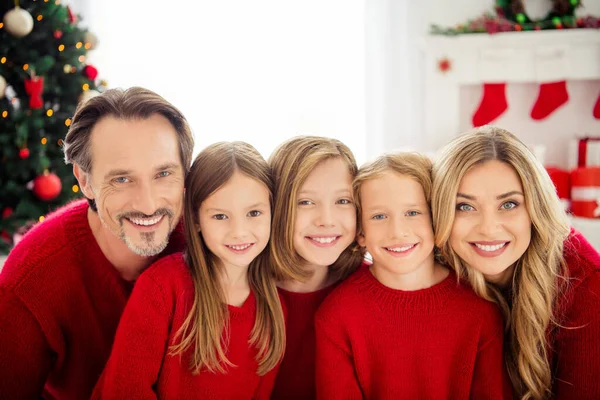 Foto van het hele gezin vijf mensen verzamelen van drie kleine kinderen knuffelen tanden glimlachen dragen rode trui in ingerichte woonkamer x-mas voorbereiding evergreen boom lichten gift dozen binnen — Stockfoto