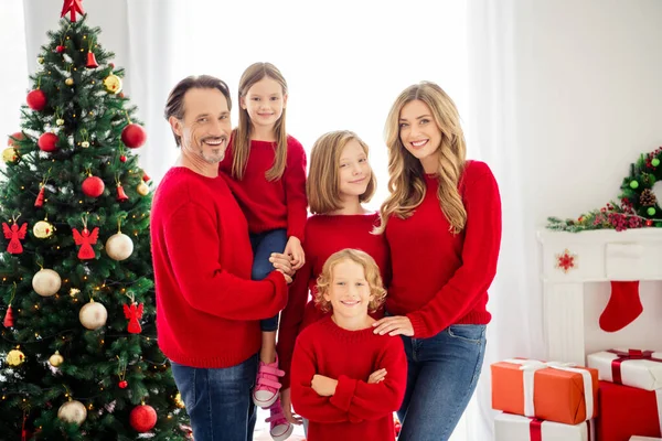 Foto van het hele gezin vijf mensen verzamelen drie kleine kinderen vader omhelzen dochter jongen gekruiste armen dragen rode trui in de avond woonkamer x-mas boom lichten presenteren dozen binnen — Stockfoto