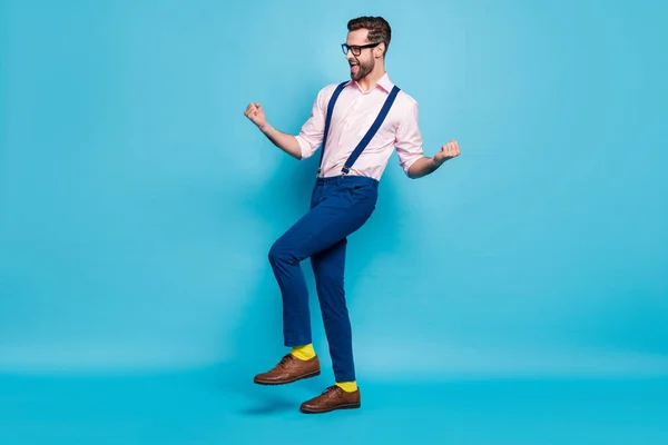 Full size photo of handsome business man successful young promoted worker raise fists excited win corporate competition wear specs shirt suspenders pants shoes isolated blue color background — Stock Photo, Image