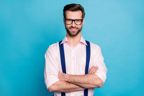 Foto van knappe macho vrolijke zakenman coole trend kleding man glimlach zonder tanden gezichtsvermogen specs armen gekruist dragen roze shirt bretels geïsoleerde pastel blauwe kleur achtergrond — Stockfoto