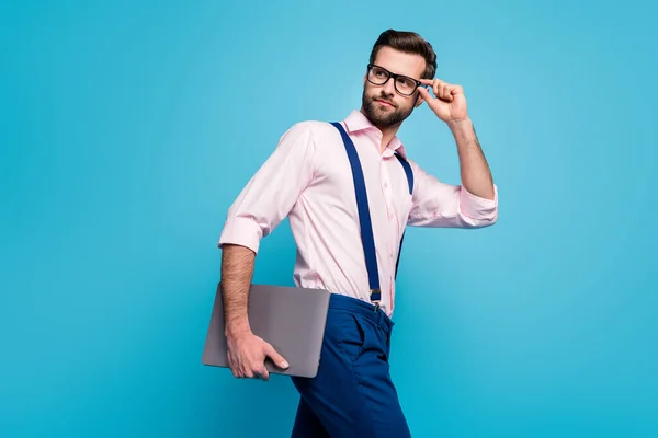 Foto de perfil del hombre de negocios seguro guapo mantenga la computadora caminar reunión oficina jefe exitoso trabajador jefe usar especificaciones camisa tirantes pantalones aislados color azul fondo — Foto de Stock