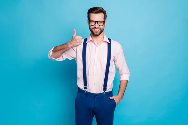 Bild av stilig macho affärsman trend kläder kille toothy leende syn vision specs höja tumme upp expressavtal bära rosa skjorta hängslen byxor isolerad blå färg bakgrund — Stockfoto