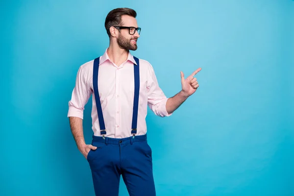 Photo of handsome business man trend clothes guy beaming smile eyesight vision specs direct finger side empty space wear pink shirt suspenders pants isolated pastel blue color background — Stock Photo, Image