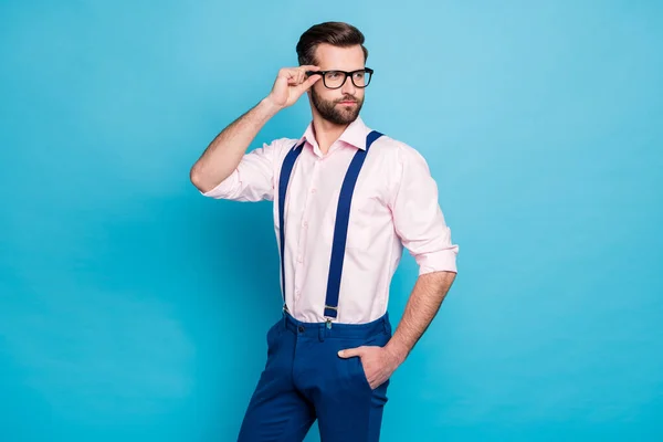 Photo of handsome macho business man cool clothes guy eye care vision touch hand specs look side empty space wear pink shirt suspenders pants isolated pastel blue color background — Zdjęcie stockowe