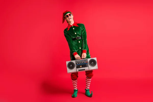 Comprimento total foto legal elfo segurar boom caixa x-mas Natal festa desgaste verde traje isolado no vermelho brilho cor fundo — Fotografia de Stock
