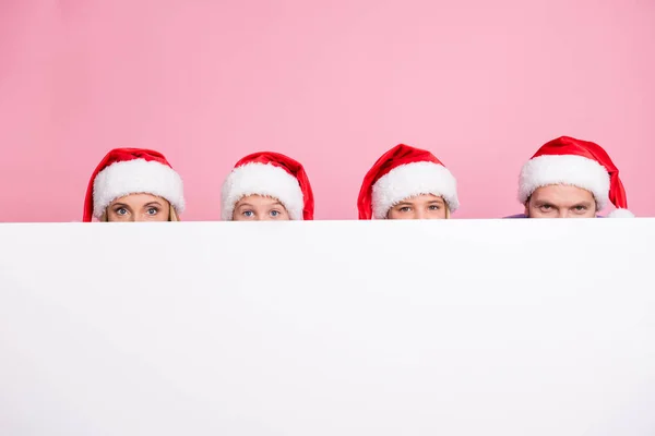 Foto di persone mamma mamma papà papà bambini piccoli nascondere le facce su bianco copia spazio indossare cappello Babbo Natale isolato colore rosa sfondo — Foto Stock