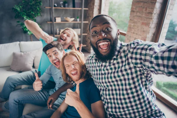 Quatro homens loucos reunindo sentar conforto sofá aconchegante desfrutar de férias de viagem fazer selfie mostrar polegar para cima sinal piada v-sinal orelhas de coelho imaginário blogging influenciador em casa dentro de casa — Fotografia de Stock