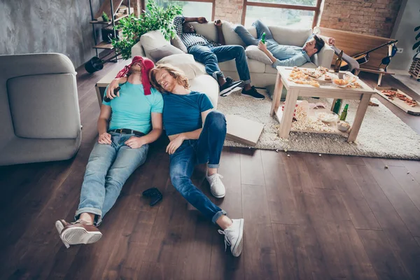 Boven hoge hoek uitzicht volledige lichaam foto van vier kerels hebben gekke nacht leven partij voelen kater slaap vloer bank hebben vrouw rood ondergoed hoofd houden leeg bier fles in huis binnen — Stockfoto