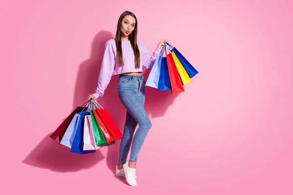 Pełny rozmiar zdjęcie marzycielski flirt dziewczyna centrum handlowe klient trzymać wiele toreb wysłać pocałunek powietrza nosić liliowy styl stylowy modny sweter dżinsy izolowane na pastelowym tle kolor — Zdjęcie stockowe