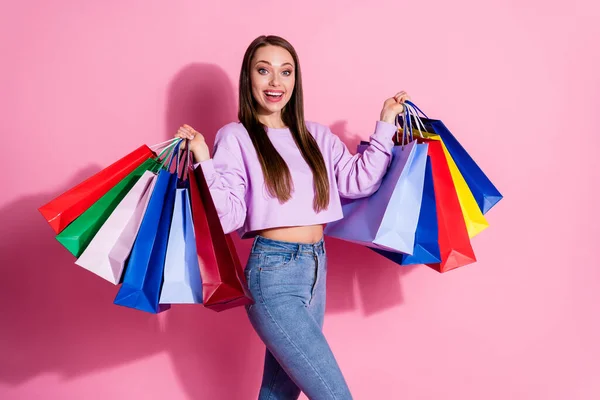 Φωτογραφία του θετικού χαρούμενα κορίτσι απολαμβάνουν χαρά ψώνια off-sales κατέχουν πολλές τσάντες φορούν λιλά στυλ κομψό trendy jumper απομονώνονται σε παστέλ χρώμα φόντο — Φωτογραφία Αρχείου