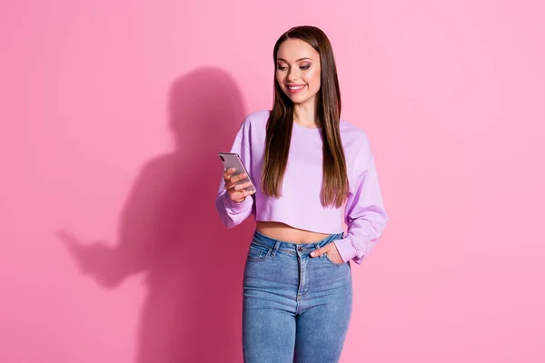 Фото позитивної дівчини використовують смартфон, щоб читати новини соціальних мереж Підписатися на спільне використання одягу фіолетовий джемпер ізольований на пастельному кольоровому фоні — стокове фото